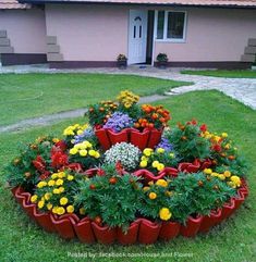 a red flower pot filled with lots of flowers