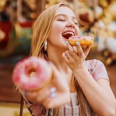 a woman is eating a doughnut and smiling