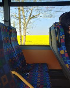 a person sitting on a bus with their head resting on the back of the seat