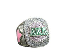 a pink and green ring with the letters aka on it's center surrounded by diamonds