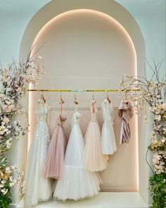 wedding dresses hanging in front of an archway