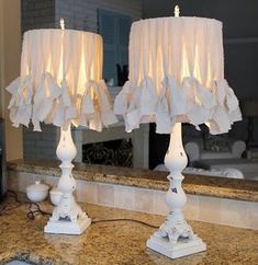 two white lamps sitting on top of a counter