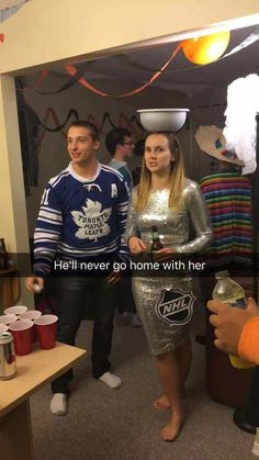 two people dressed up in costumes standing next to each other and one person holding a beer