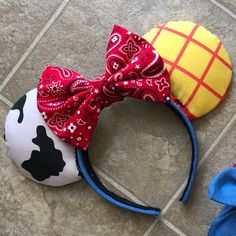 two mickey mouse ears with red and yellow designs on them, one is wearing a bandana