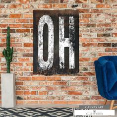 a blue chair in front of a brick wall with the word oh painted on it