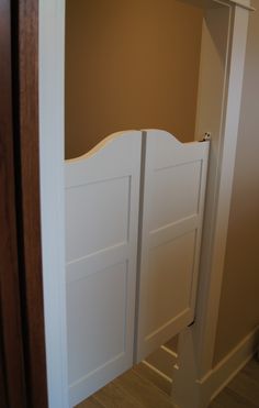 an open closet door with white paneling and wooden floors in a home under construction