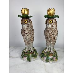 two owl figurines with flowers on their heads