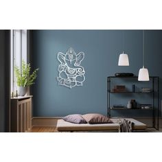 a room with blue walls and a white metal wall hanging on the wall next to a bed