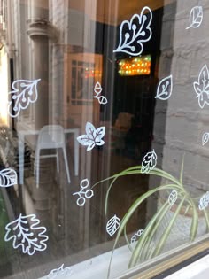 the window is decorated with white flowers and leaves on it's glass sill