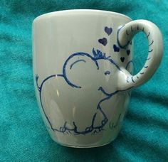 a coffee cup with an elephant painted on the side and hearts drawn on the inside