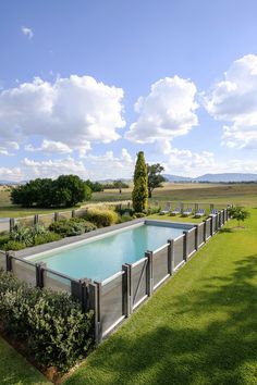 an empty swimming pool surrounded by lush green grass