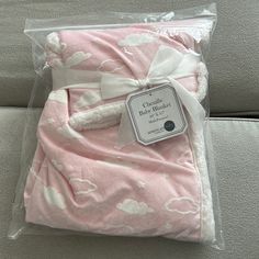 a pink blanket with white clouds on it