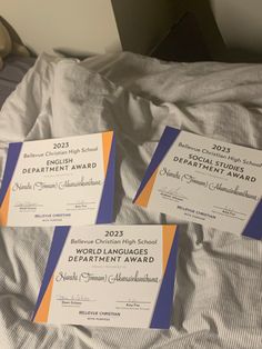 three certificates sitting on top of a bed