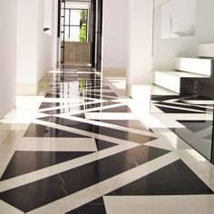 an empty hallway with black and white tiles on the floor