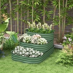 three tiered planters in the middle of a garden with white flowers and greenery