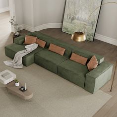 a large green couch sitting in a living room next to a painting