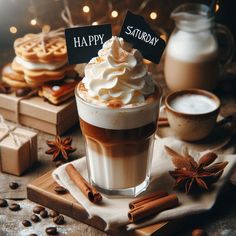 a cappuccino with whipped cream and cinnamon sticks on a wooden table surrounded by coffee beans