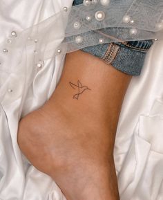 a woman's foot with a small tattoo on it