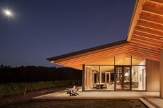 a house that is lit up at night with the moon in the sky above it