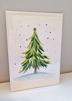 a card with a watercolor christmas tree on it