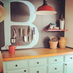 a kitchen counter with utensils hanging on the wall