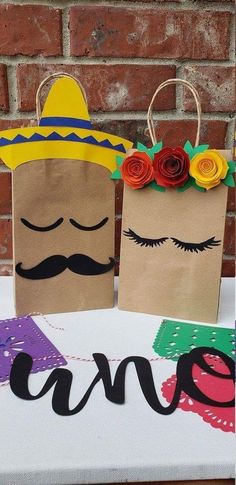 two paper bags decorated with flowers and mustaches