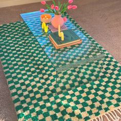 a coffee table with flowers on it in the middle of carpeted living room area