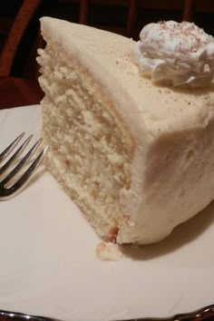 a piece of white cake on a plate with a fork and knife next to it