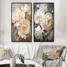 two paintings of white flowers in a living room