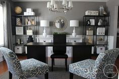 two chairs sitting in front of a black table with white and blue upholstered chairs