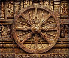 an intricately carved wheel on the side of a building