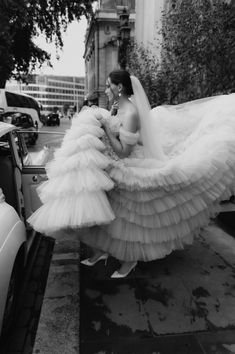 a woman in a wedding dress walking down the street