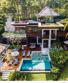 an aerial view of a house with a pool in the yard and trees surrounding it