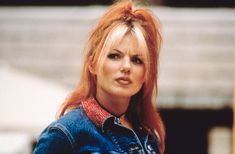 a woman with red hair wearing a jean jacket