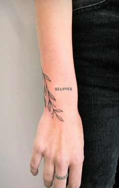 a woman's hand with a tattoo that reads beloved