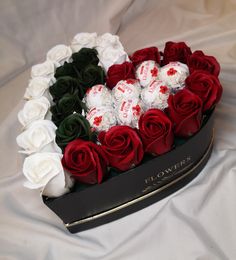 a heart shaped box filled with roses and chocolates