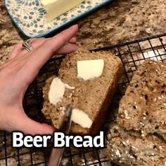 a person is cutting bread with butter on it and the words beer bread written in front of them