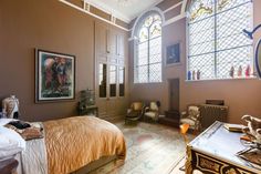 a bedroom with stained glass windows and a bed in the corner, along with other furniture