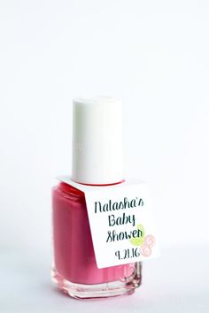 a bottle of nail polish sitting on top of a white table next to a tag