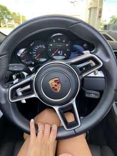 a woman is sitting in the driver's seat of a car with her hands on the steering wheel