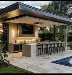 an outdoor kitchen next to a swimming pool