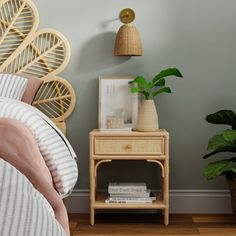 a bed room with a neatly made bed and two planters on the nightstands