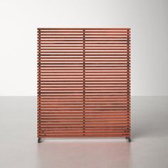 a wooden slatted screen on a grey surface with an empty wall in the background