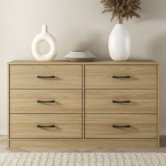 a white vase sitting on top of a wooden dresser