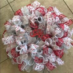 a red and white mesh wreath with the word hello kitty on it's center