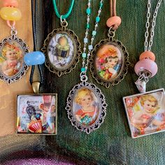 several necklaces with pictures hanging from them