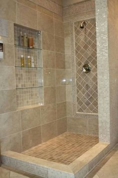 a walk in shower sitting next to a tiled wall