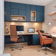 a home office with blue cabinets and an orange chair