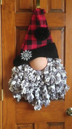 a door hanger with a snowflake hat and scarf on it's head