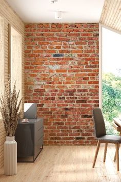 an empty room with a brick wall and wooden flooring is pictured in this image